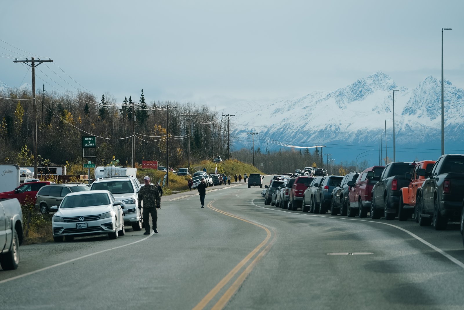 Vehicles parked along road near mountains