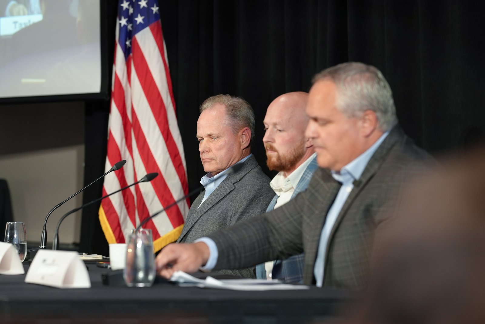 Three men at a formal panel discussion