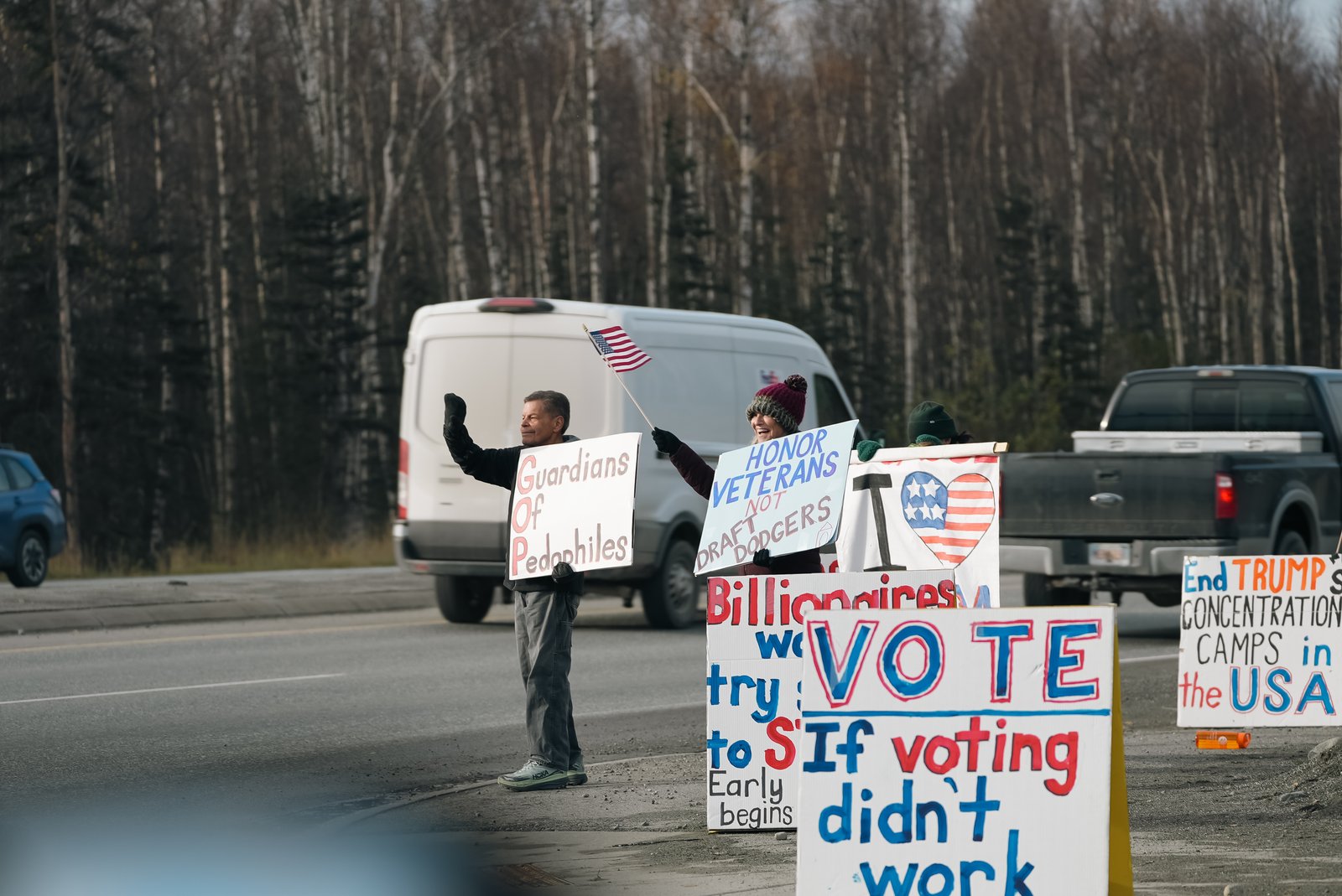 Protesters holding political signs on roadside